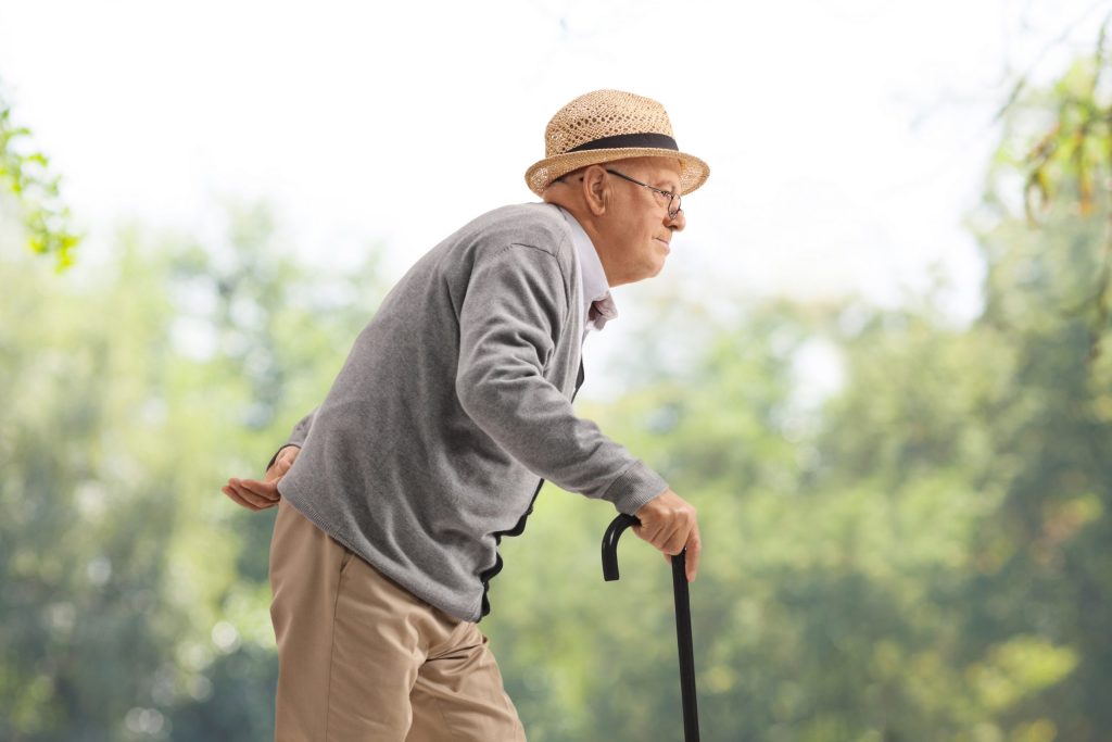 Old Man With Cane Stooped Posture Scaled